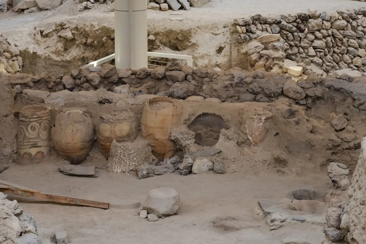Excavated Bronze Age walls and storage jars at the Akrotiri archaeological site, Santorini