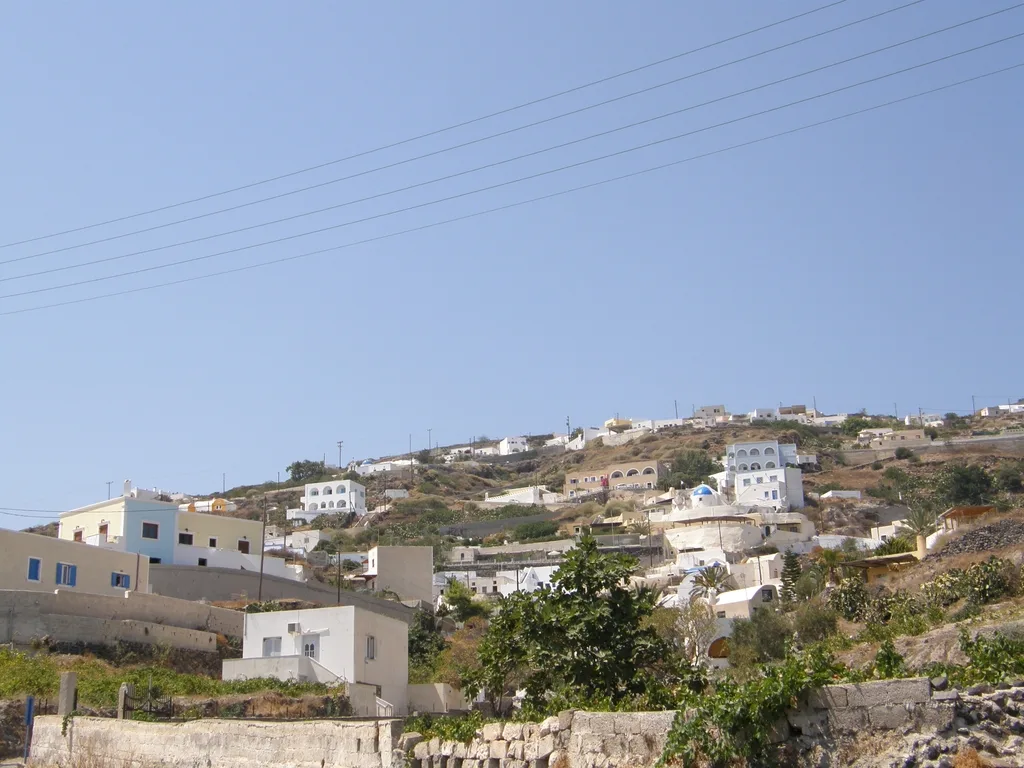 White houses of Vourvoulos spread across a hillside in Santorini